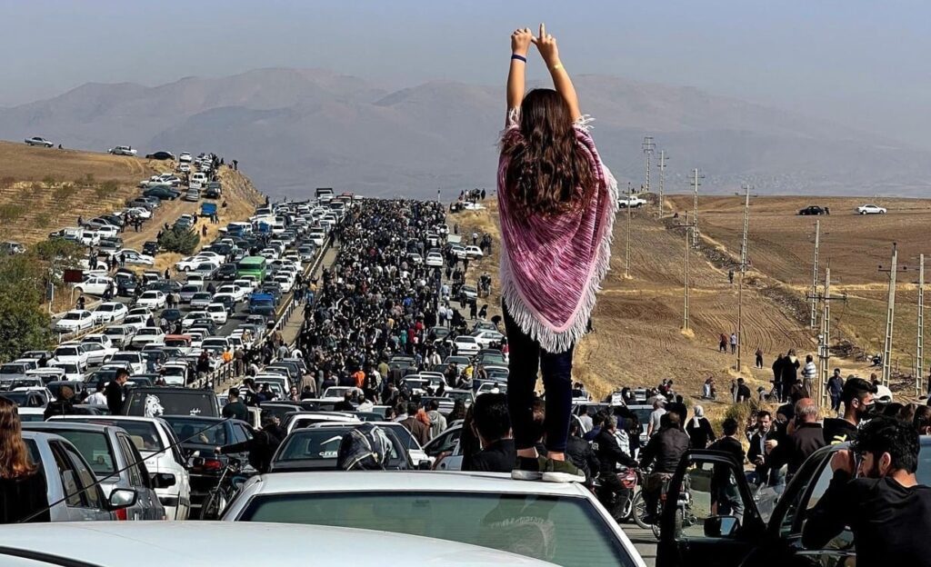 Mujer sin velo sobre vehículos en Mahsa Amini